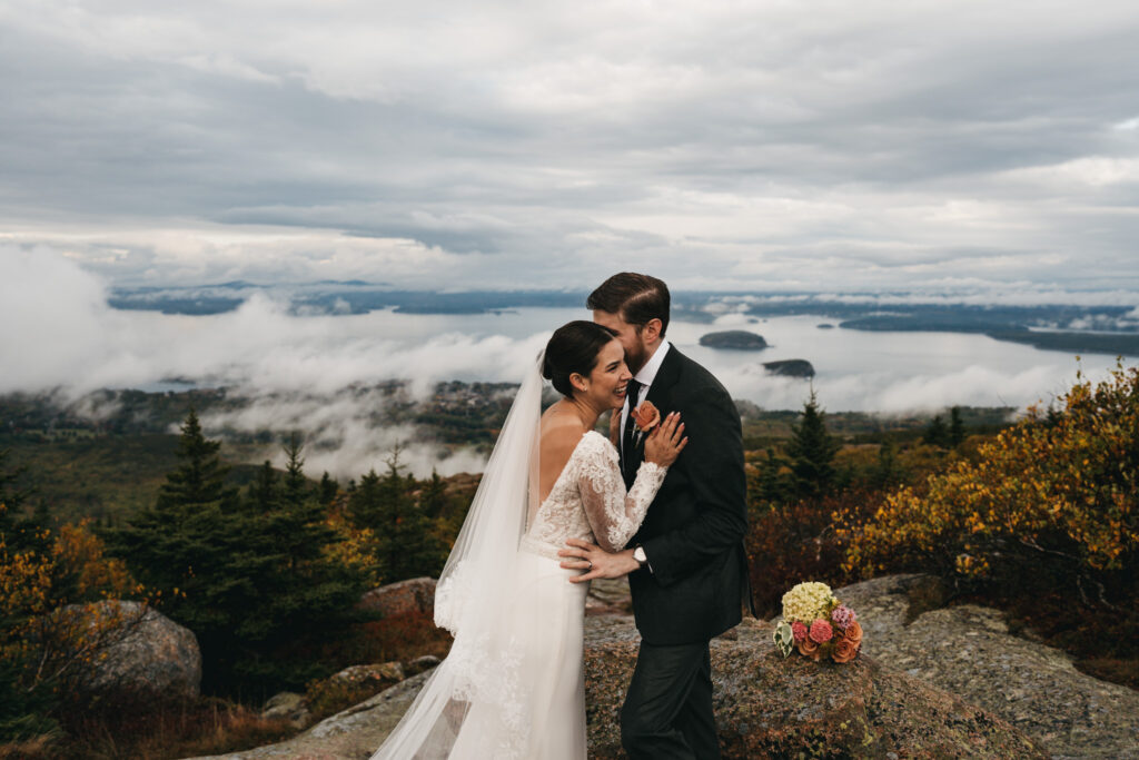 Bride and groom portraits in Acadia National Park with clouds rolling through the mountains