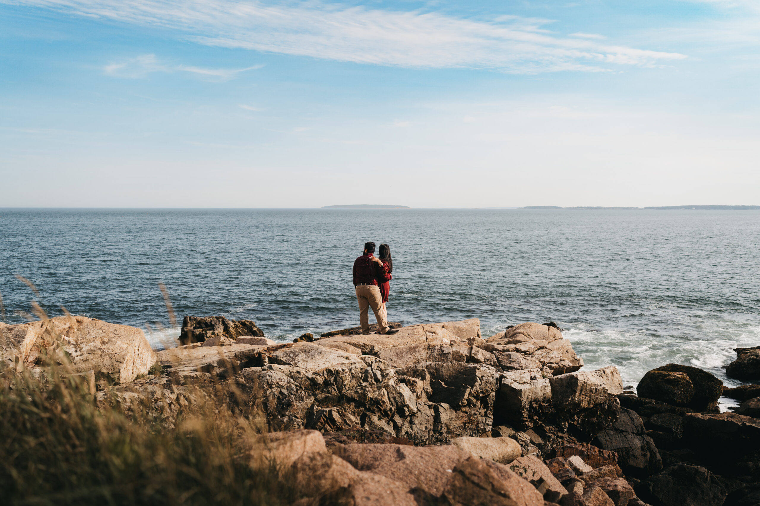 Couple standing on the rocky coastline at Otter Point in Acadia National Park during an adventure session