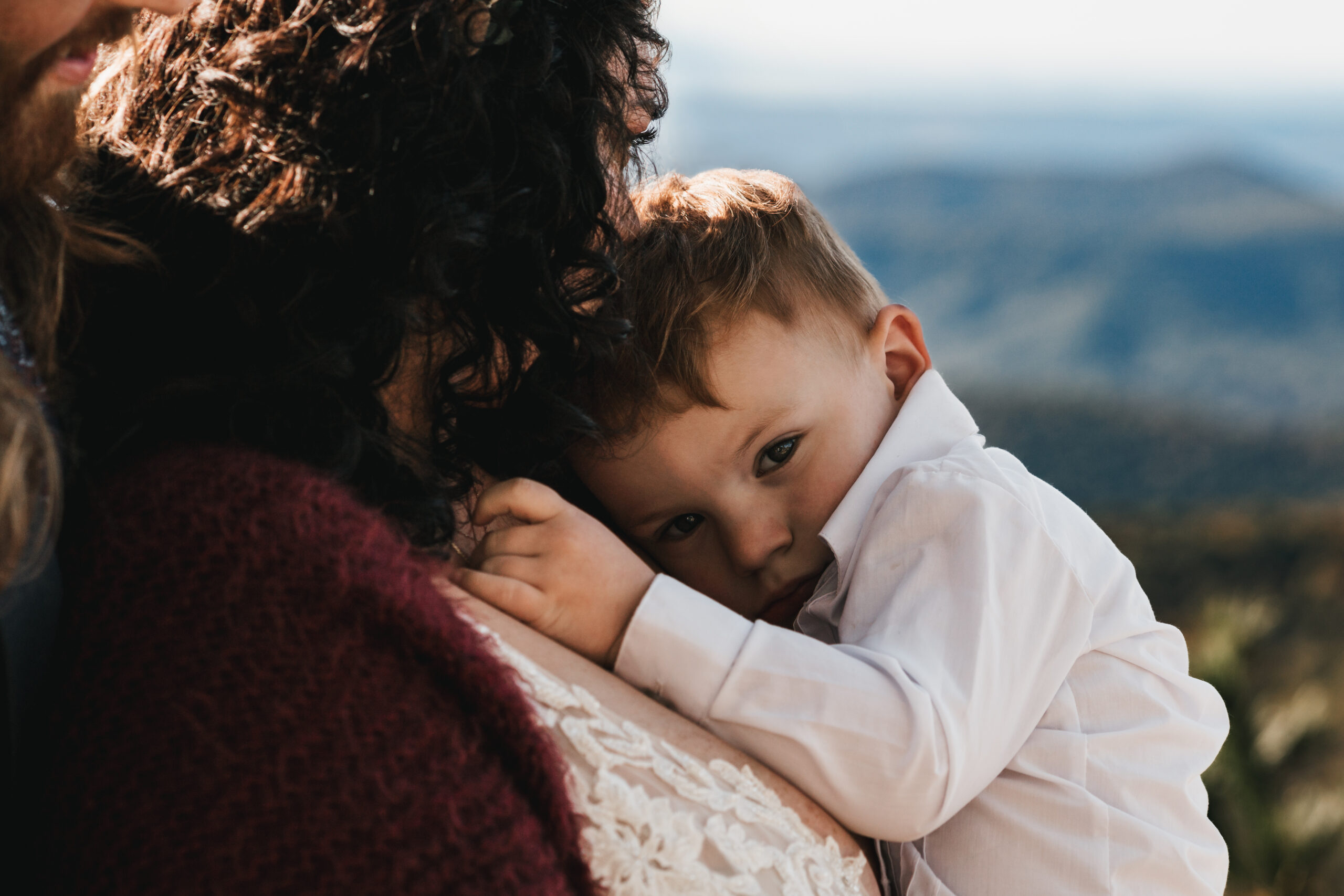 Bride holding her son closely at the point overlook in Shenandoah National Park
