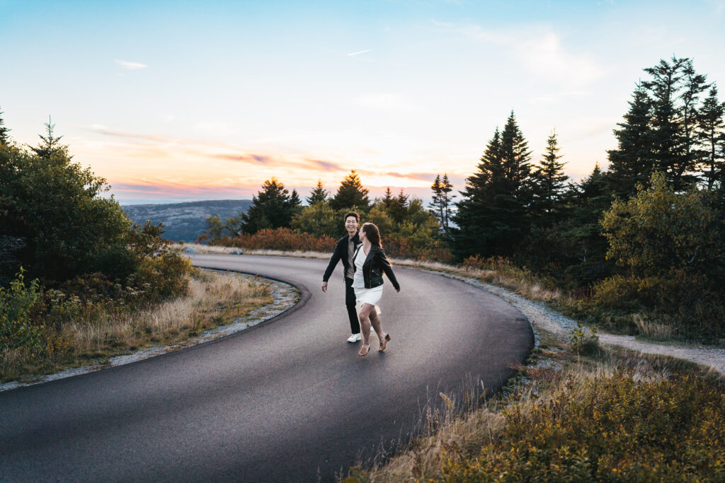 Couple running along the road at Cadillac Mountain during sunset