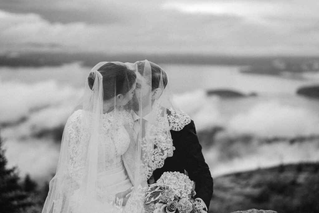 Bride and groom portraits in Acadia National Park with clouds rolling through the mountains