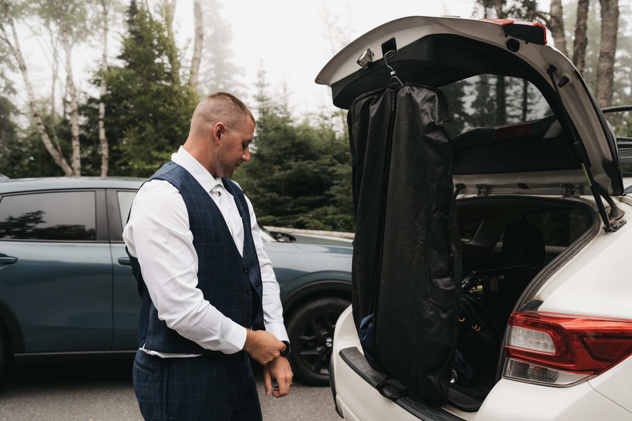 Groom adjusting his suit before an intimate first look.