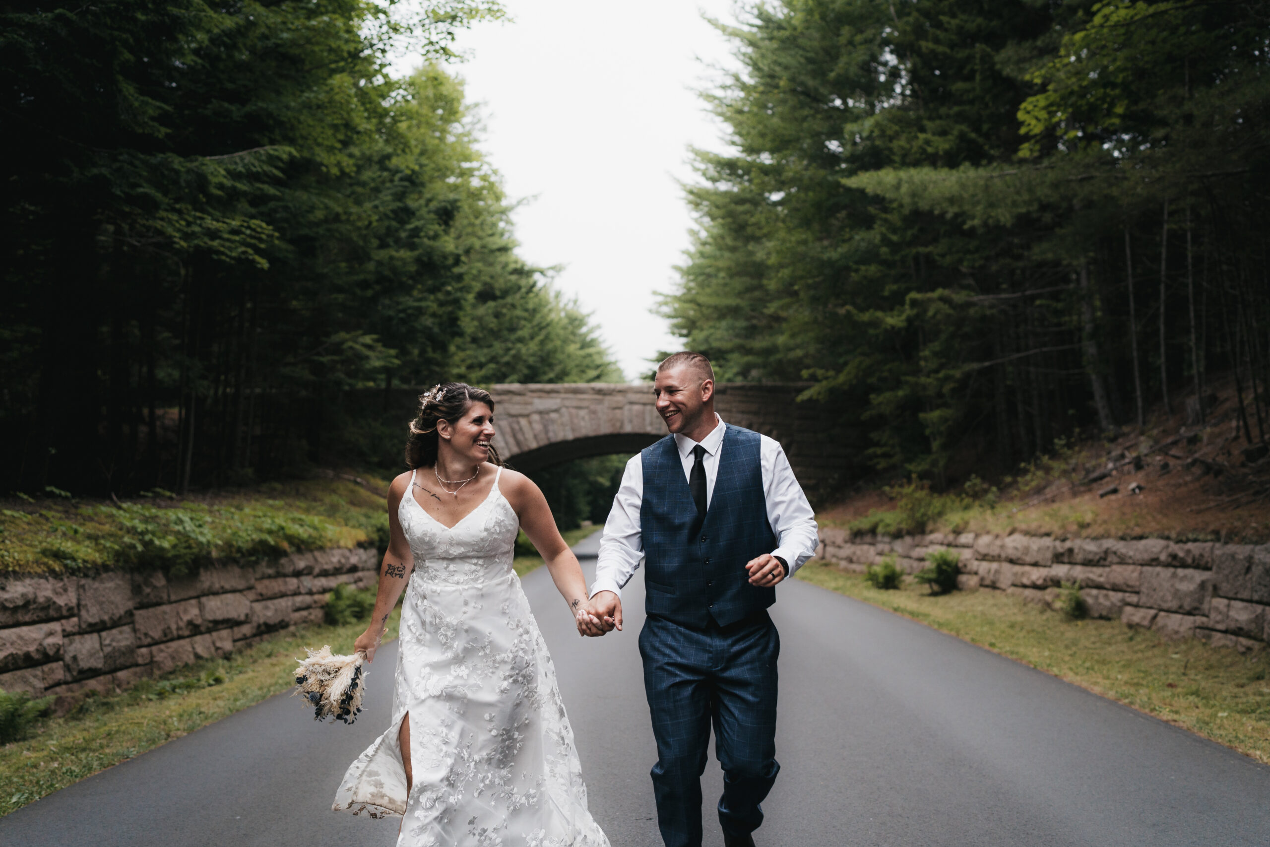 Newlyweds running through Acadia National Park.