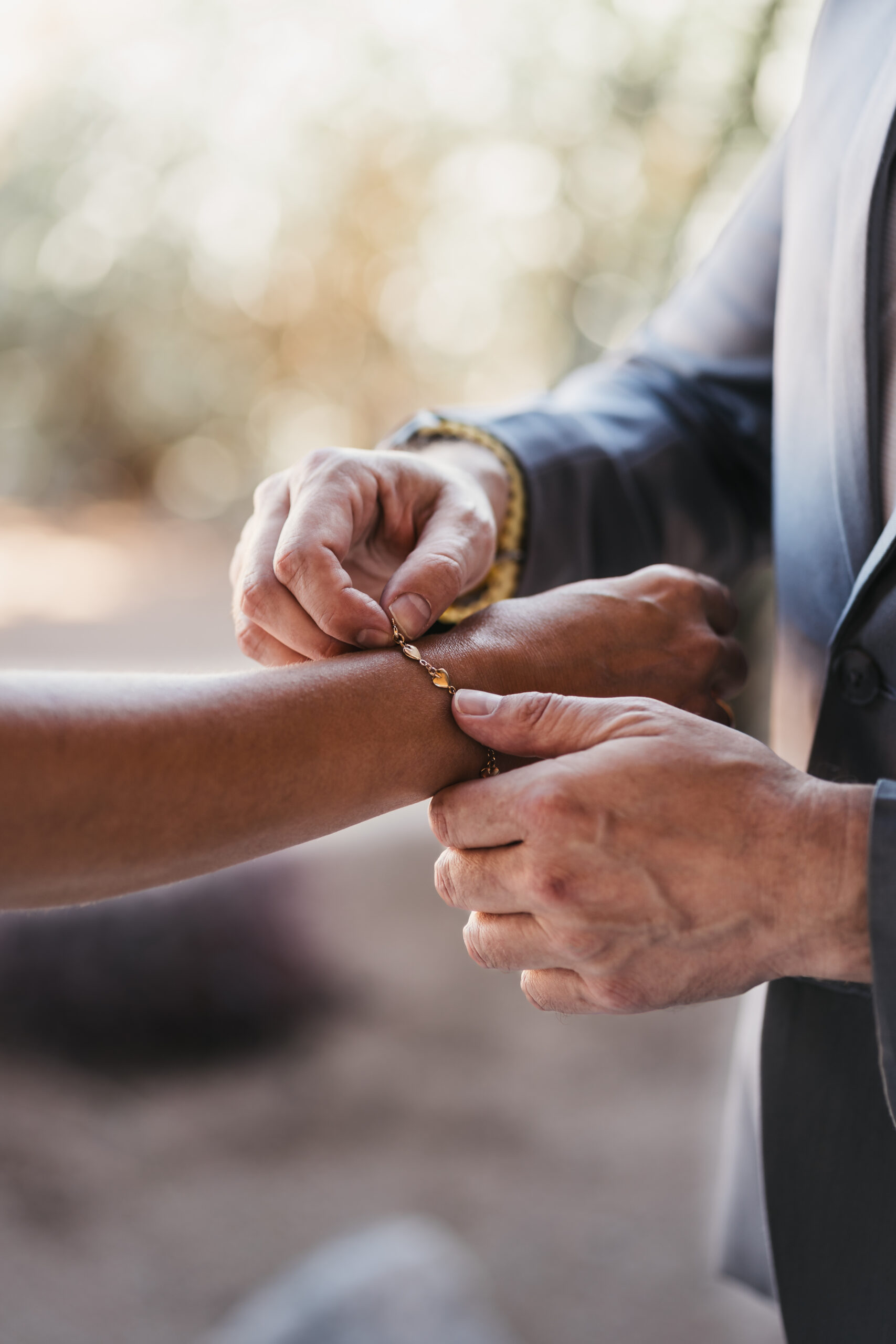 Best man helping bride put on her bracelet.