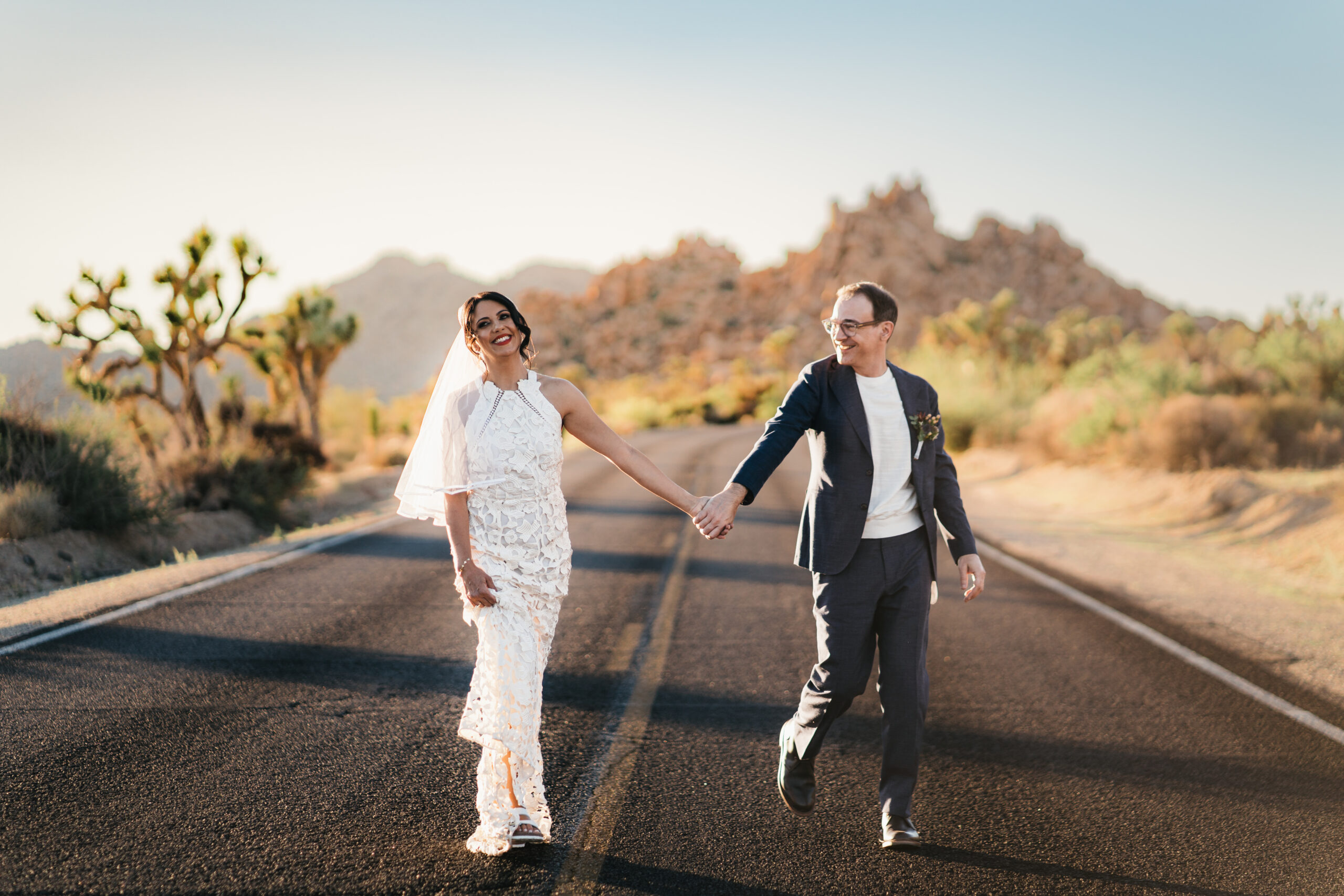 Couple laughing together in the middle of the street in Joshua Tree National Park.