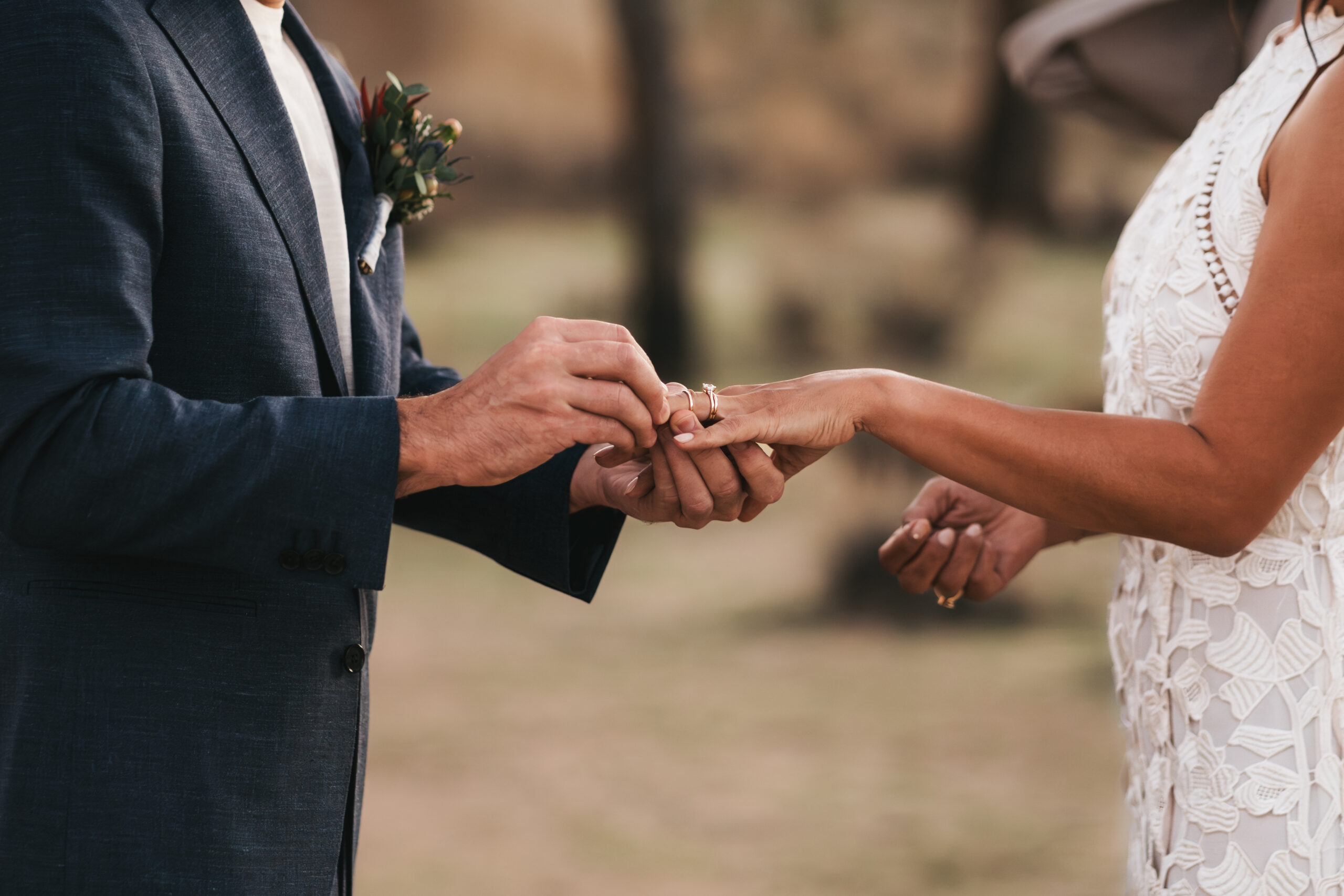 Groom putting ring on brides finger during their Joshua Tree elopement.