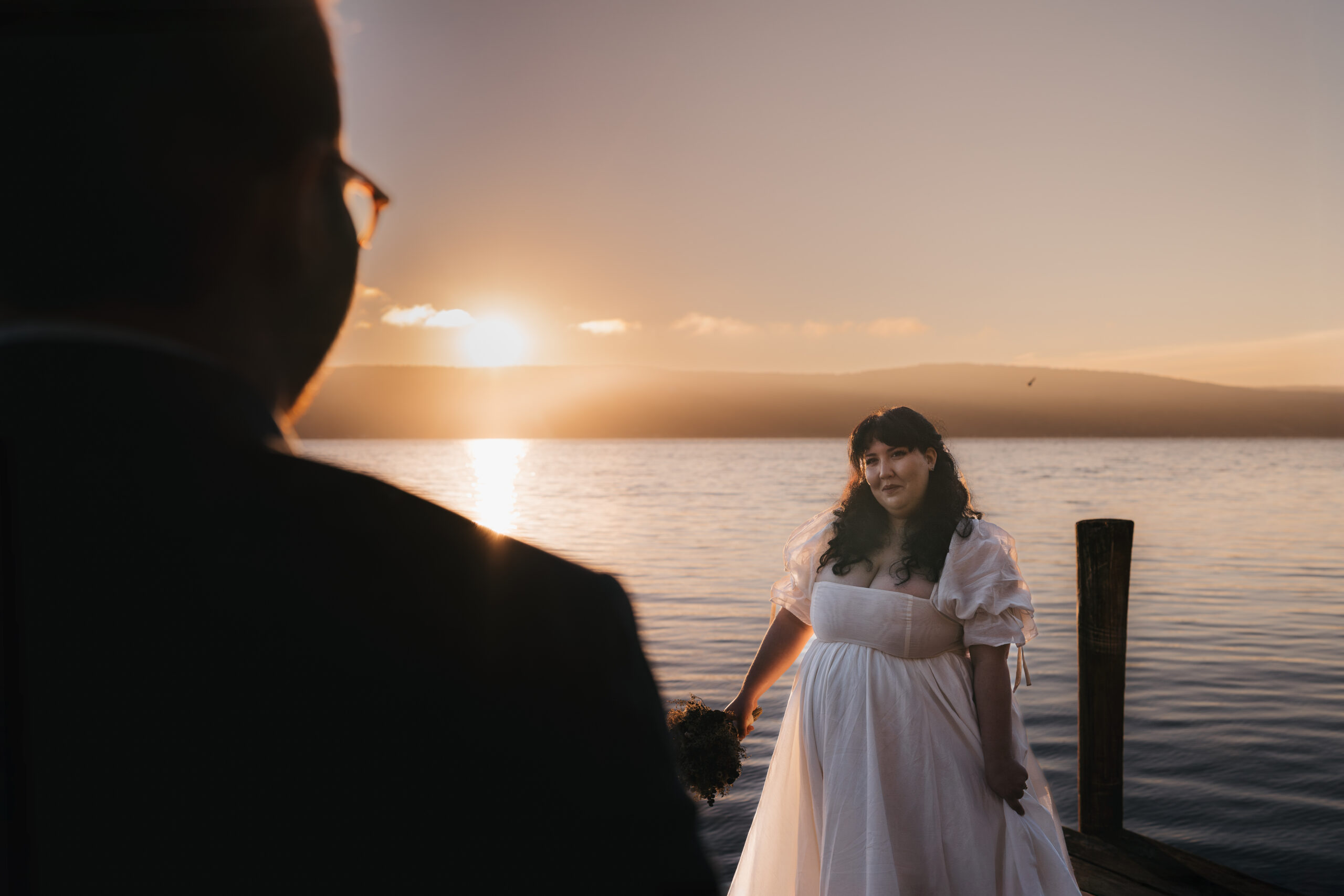 Bride admiring her groom during their sunrise elopement on Seneca Lake.