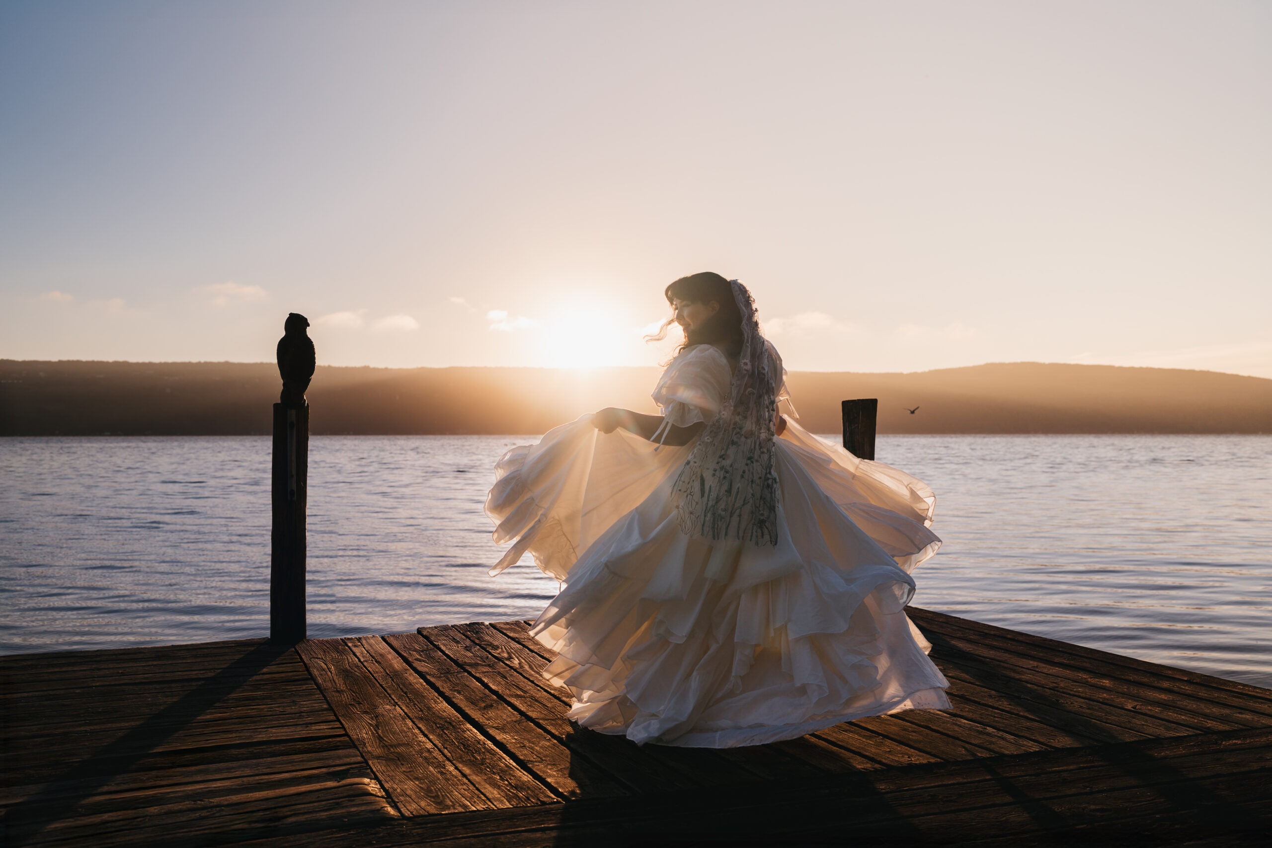 Bride twirling in her dress during her sunrise elopement on Seneca Lake.