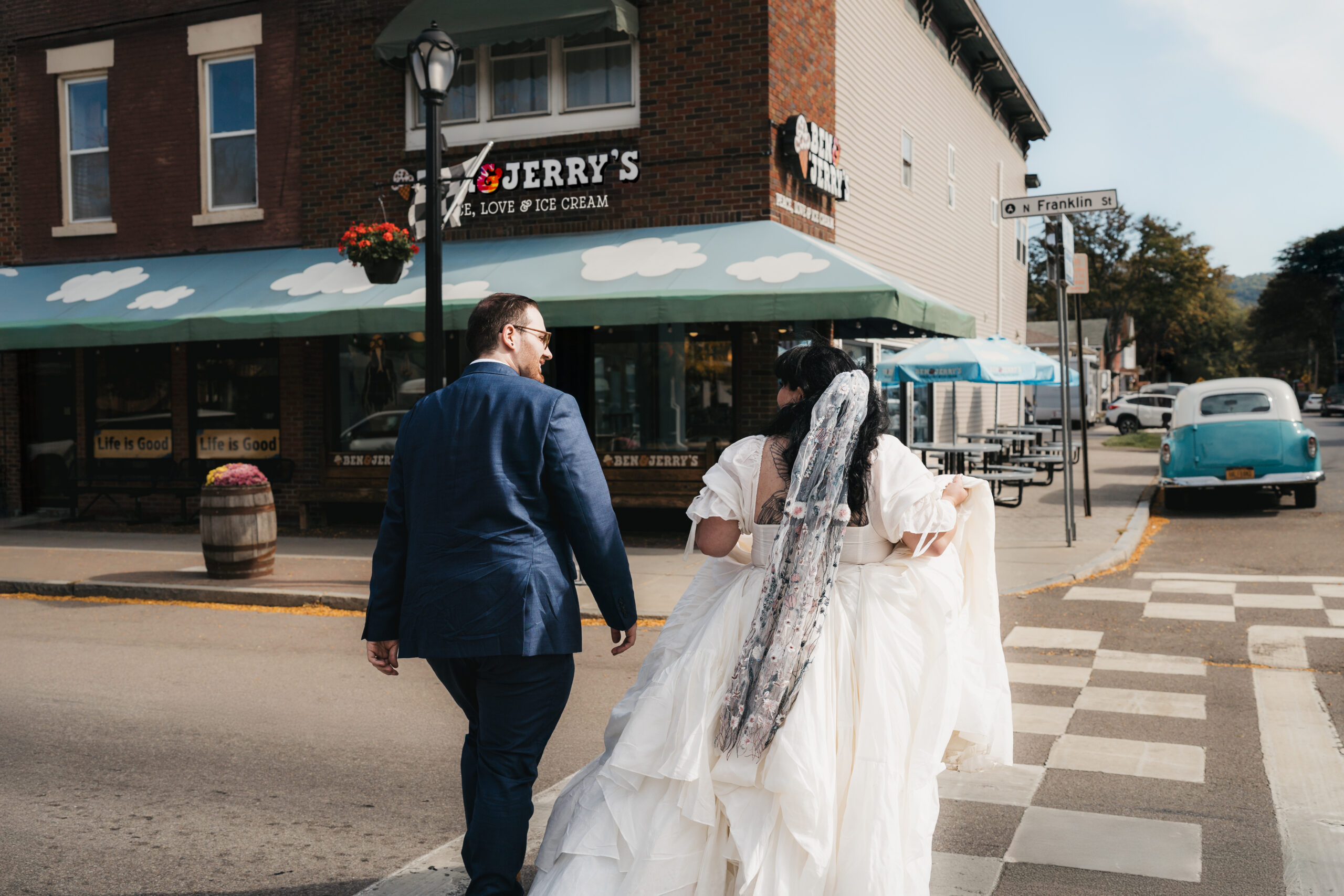 Newlyweds laughing together during a stop at Ben & Jerry’s after their Watkins Glen elopement.