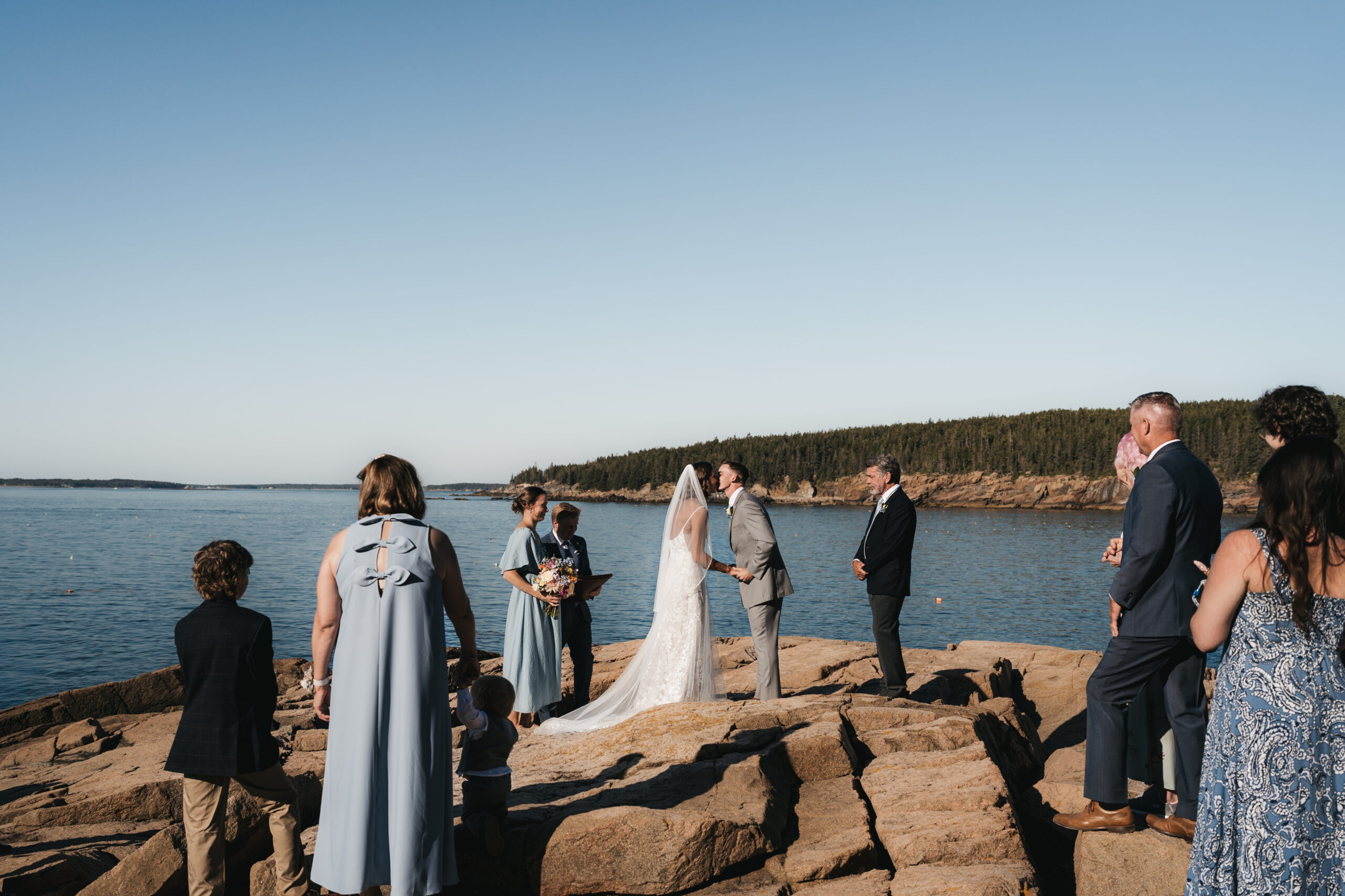 Newlyweds share a first kiss in Acadia National Park.