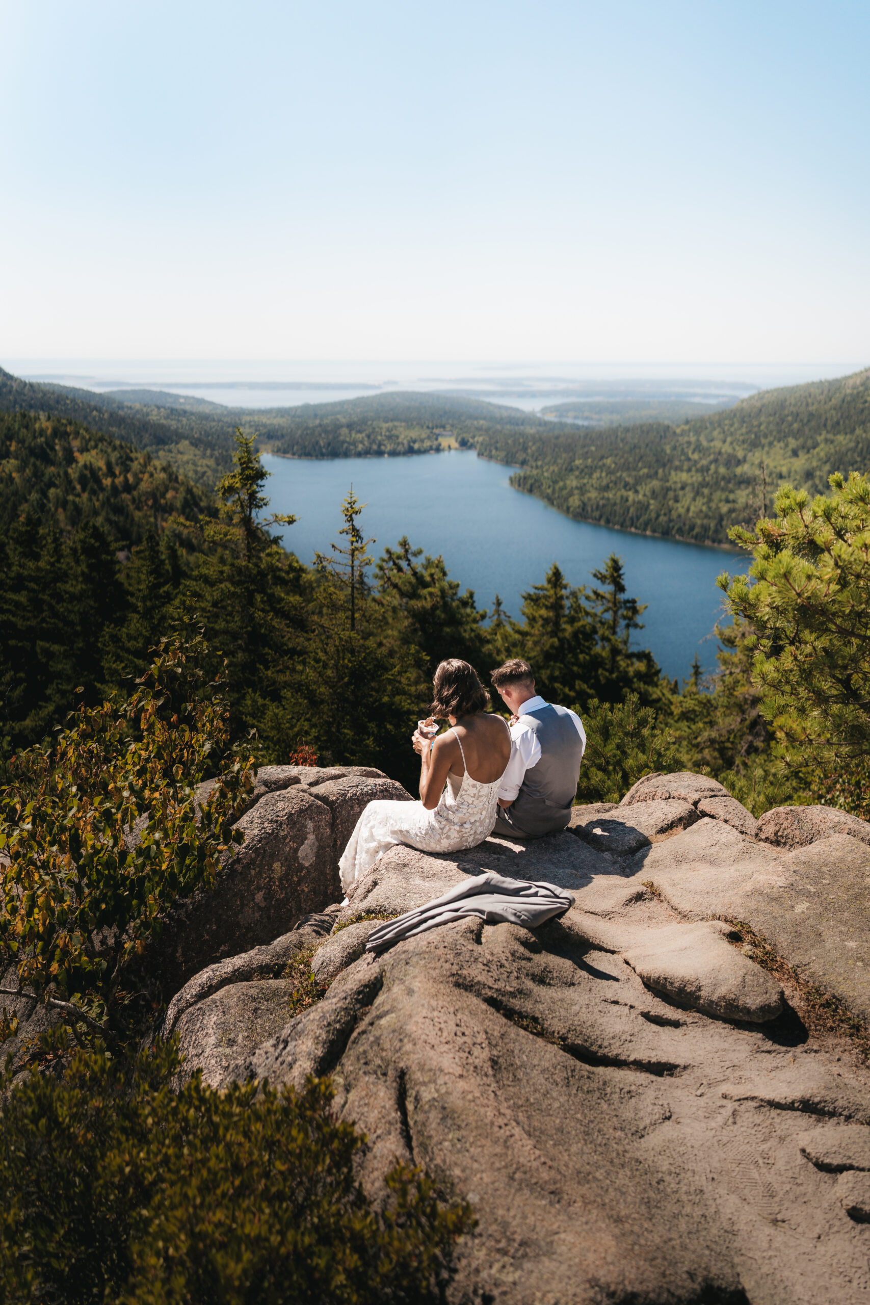 Couple sharing ice cream overlooking Jordan Pond during a Sunrise Acadia Elopement.